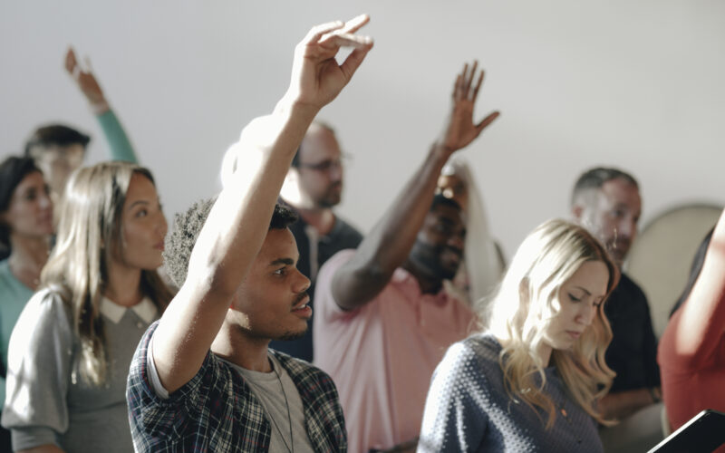 People raising their hands in a seminar