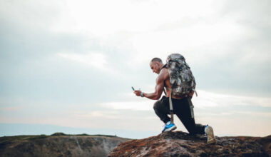 Young Caucasian Muscular Man On A Hike, Checking Compass.